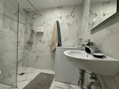 a white bathroom with a sink and a shower at Cecilia's cozy flat in Athens