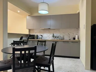 a kitchen with a table and chairs in a kitchen at Cecilia's cozy flat in Athens
