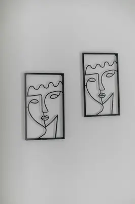 two framed drawings of heads on a wall at Serene City Hideaway with Balcony & Modern Comfort in Athens