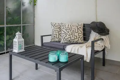 a bench and a table with blue candles on it at Serene City Hideaway with Balcony & Modern Comfort in Athens