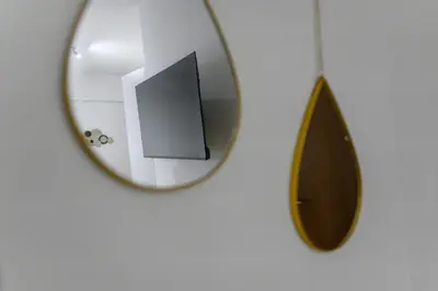 a mirror hanging on a white wall with a surfboard at Serene City Hideaway with Balcony & Modern Comfort in Athens