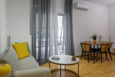 a living room with a couch and a table at Serene City Hideaway with Balcony & Modern Comfort in Athens
