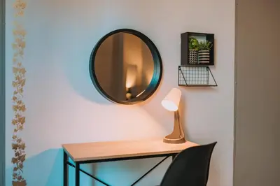 a mirror on a wall next to a desk with a lamp at 4BED apartment in the center of Athens in Athens