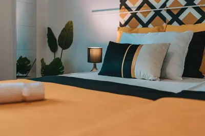 a bedroom with a bed with an orange blanket and pillows at 4BED apartment in the center of Athens in Athens
