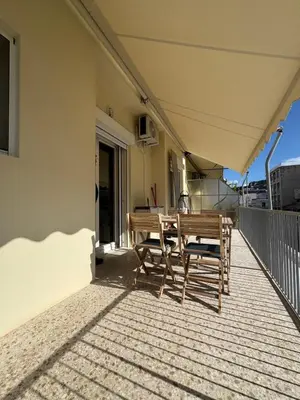 a patio with a table and chairs on a balcony at Cecilia's cozy apartment in Athens