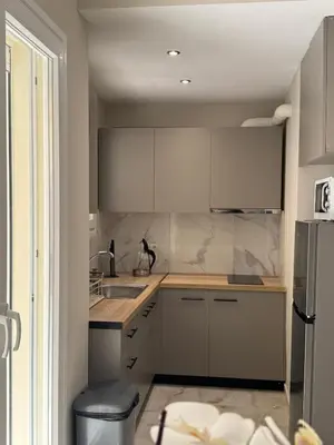 a kitchen with white cabinets and a sink at Cecilia's cozy apartment in Athens