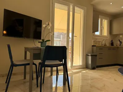 a kitchen with a table and two chairs and a window at Cecilia's cozy apartment in Athens