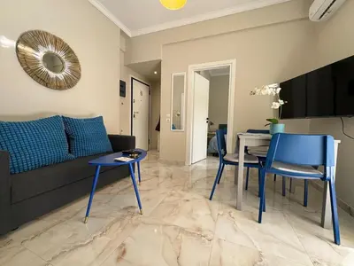 a living room with a couch and a table and chairs at Cecilia's cozy apartment in Athens