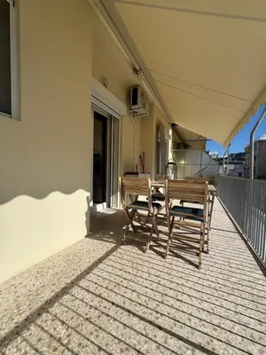 a patio with a table and chairs on a balcony at Cecilia's cozy apartment in Athens