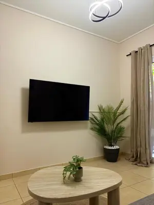 a living room with a table and a tv on the wall at In the heart of Athens in Athens