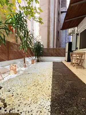 a courtyard with rocks and trees in a building at In the heart of Athens in Athens