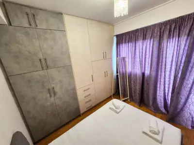 a room with a bed and a purple curtain at Tender Bliss in Athens