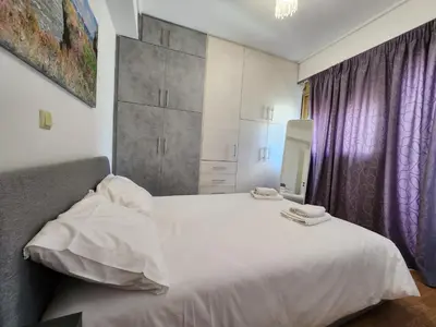 a bedroom with a white bed and purple curtains at Tender Bliss in Athens