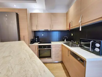 a kitchen with wooden cabinets and a counter top at Tender Bliss in Athens