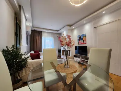 a living room with a vase of flowers on a glass table at Tender Bliss in Athens
