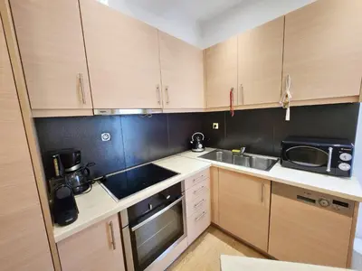 a kitchen with wooden cabinets and a sink and a microwave at Tender Bliss in Athens