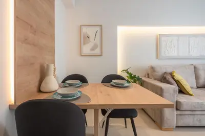 a living room with a wooden table and chairs at Exclusive Suite by CloudKeys in Athens