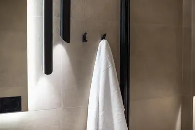 a bathroom with a towel hanging on a shower stall at Exclusive Suite by CloudKeys in Athens