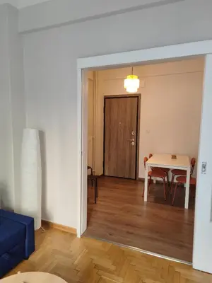 a living room with a table and a blue couch at Freshly Renovated Appartment in Athens