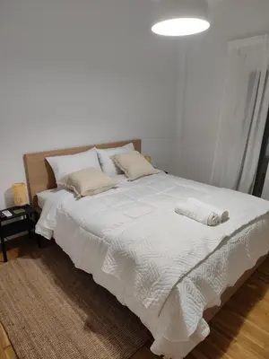 a bedroom with a bed with white sheets and pillows at Freshly Renovated Appartment in Athens