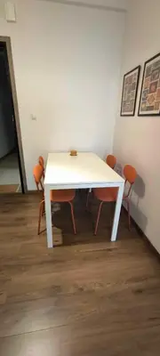 a white table with orange chairs in a room at Freshly Renovated Appartment in Athens