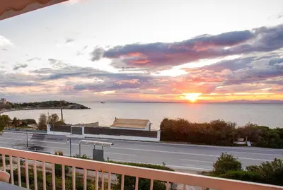 a view of a road and the ocean at sunset at Apartment by the beach in Anavissos