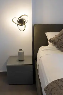 a lamp on a nightstand next to a bed at Apartment by the beach in Anavissos