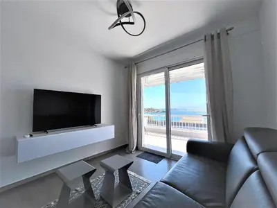 a living room with a couch and a large window at Apartment by the beach in Anavissos