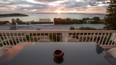 a table on a balcony with a view of the ocean at Apartment by the beach in Anavissos