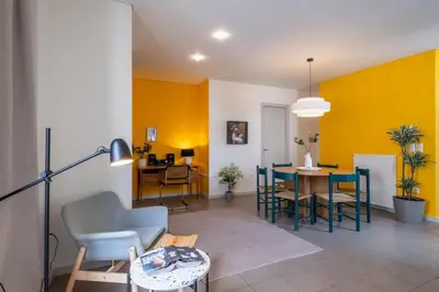 a living room with yellow walls and a table and chairs at Award-winning Yellow-spot in Athens