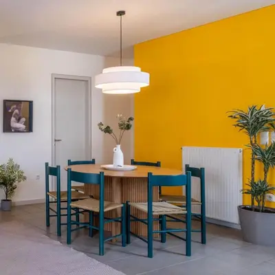 a dining room with a table and chairs and a yellow wall at Award-winning Yellow-spot in Athens