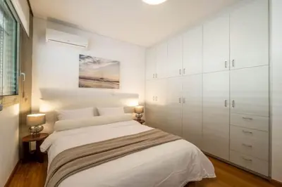 a white bedroom with a bed and white cabinets at Award-winning White-spot in Athens