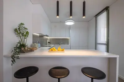 a kitchen with a counter with two stools and a sink at Award-winning White-spot in Athens