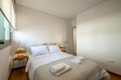 a bedroom with a large bed with two towels on it at Award-winning White-spot in Athens