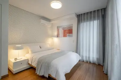 a bedroom with a white bed and a window at Award-winning White-spot in Athens