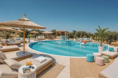 a swimming pool with lounge chairs and a swimming pool at Seven stars Camping Evelina in Keratea