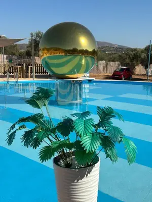 a plant in a pot in front of a pool at Seven stars Camping Evelina in Keratea