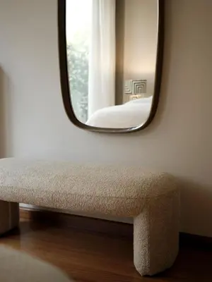 a mirror sitting on a wall next to a bench at Amanda Blue in Athens