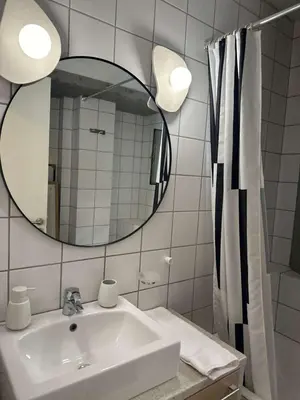 a white bathroom with a sink and a mirror at Amanda Blue in Athens