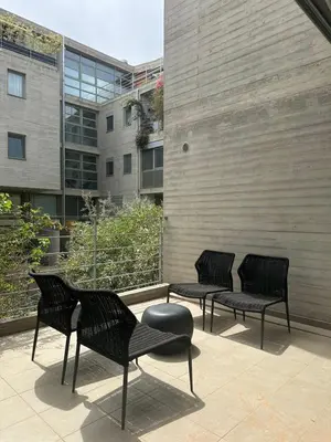 three black chairs and a table in front of a building at Amanda Blue in Athens