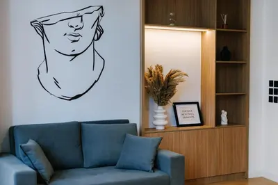 a living room with a couch and a drawing of a man at G Residence in Athens