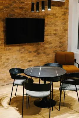 a table with chairs and a tv on a brick wall at G Residence in Athens
