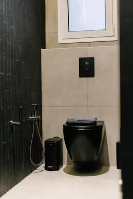a bathroom with a black toilet and a shower at G Residence in Athens