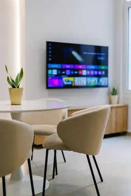 a dining room with a table and chairs and a tv at Y Residence in Athens