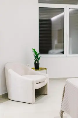 a white chair in a room with a window at Y Residence in Athens