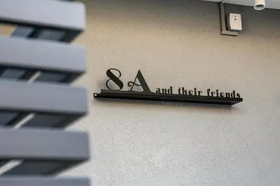 a sign that says scissors and their friends on a wall at M&H and their friends B in Athens