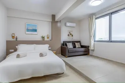 a bedroom with a large white bed and a chair at M&H and their friends B in Athens