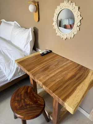 a wooden table in a bedroom with a mirror and a stool at M&H and their friends B in Athens