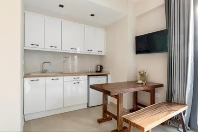 a kitchen with white cabinets and a wooden table at M&H and their friends B in Athens