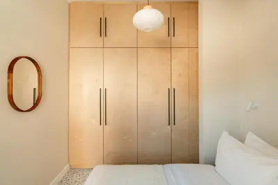 a bedroom with a large wooden cabinet next to a bed at The Verve by Zoia Living in Athens